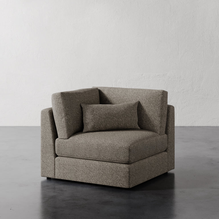 Lemieux Et Cie Lacroix Corner Chair Gray chair against a plain white wall.