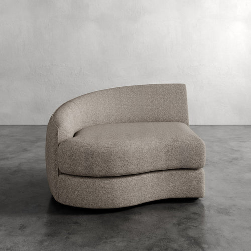 Lemieux Et Cie Rulmann Left Arm Chair  Gray upholstered chair on a concrete floor with a gray wall background