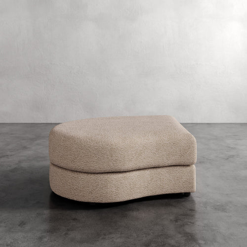 Lemieux Et Cie Rulmann Left Ottoman  Beige ottoman on a gray concrete floor with a plain white wall background