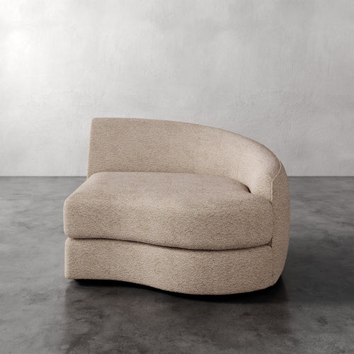Lemieux Et Cie Rulmann Right Arm Chair Beige curved sofa on a gray floor with a plain wall background