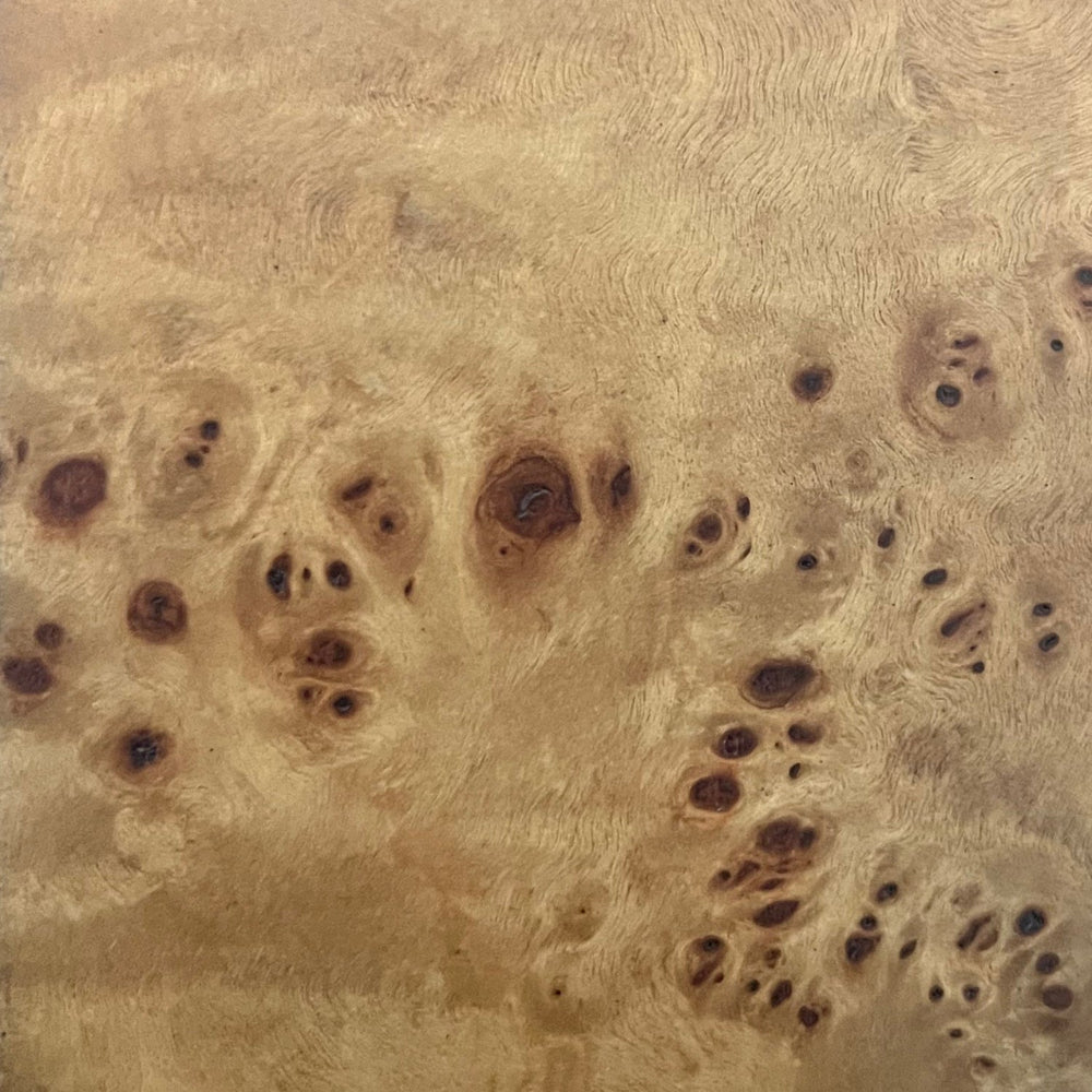 Lemieux et Cie Burl Wood Finishes swatch in warm honey tones with organic figured grain and dark knots, material sample shown on neutral surface.