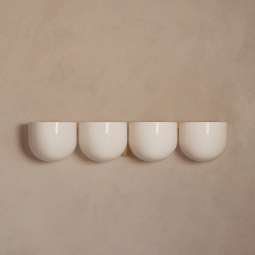 Lemieux et Cie Cocoon Lamp in resin with rounded diffuser form, set of four pendant lights shown against warm neutral walls in soft light.