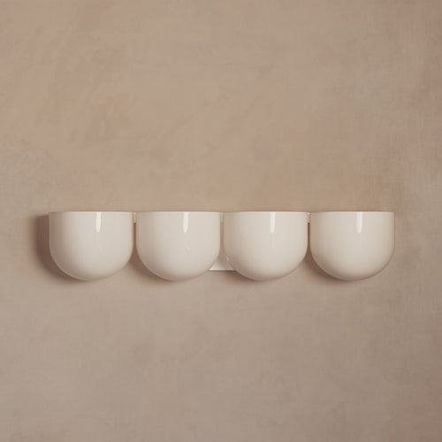 Lemieux et Cie Cocoon Lamp in ivory resin and metal, four rounded diffusers mounted on neutral plaster wall in soft light.