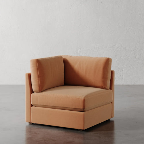 Lemieux Et Cie Chanaux Corner Chair Brown armchair on a gray floor with a white wall background