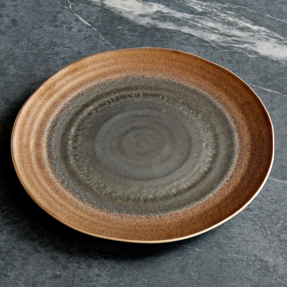 Lemieux et Cie Akita Stoneware Dinner Plate with reactive glaze and copper highlights, ceramic plate shown on gray marble surface.
