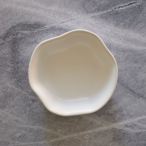Lemieux et Cie Amorphous Pasta Bowl in ivory ceramic, organic hand-shaped form shown on grey concrete surface.