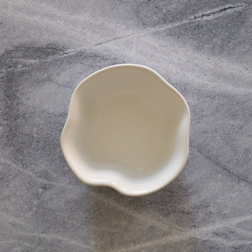 Lemieux et Cie Amorphous Bowl in soft white matte glaze, stoneware bowl with organic asymmetrical edge, shown on gray veined marble surface.