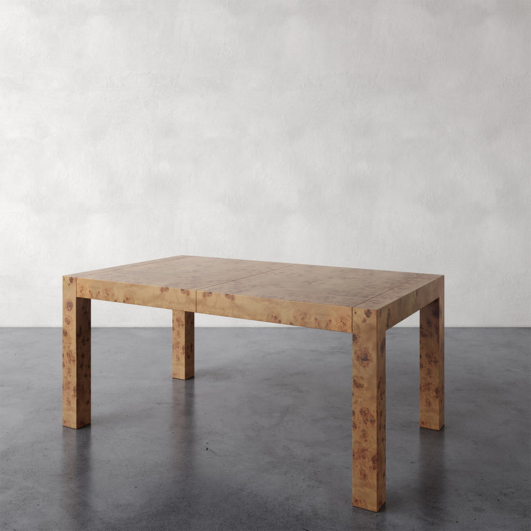 Lemieux et Cie Avenir Dresser in Mappa Burl, low-profile dining table with hand-cast brass hardware, set on dark concrete floor against textured plaster walls