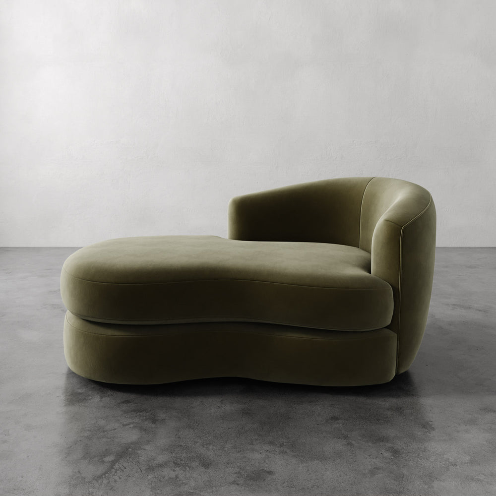 Lemieux et Cie Rulmann Right Arm Chaise in olive green leather, sculptural curved lounge with rounded arms on polished concrete floor and neutral walls.