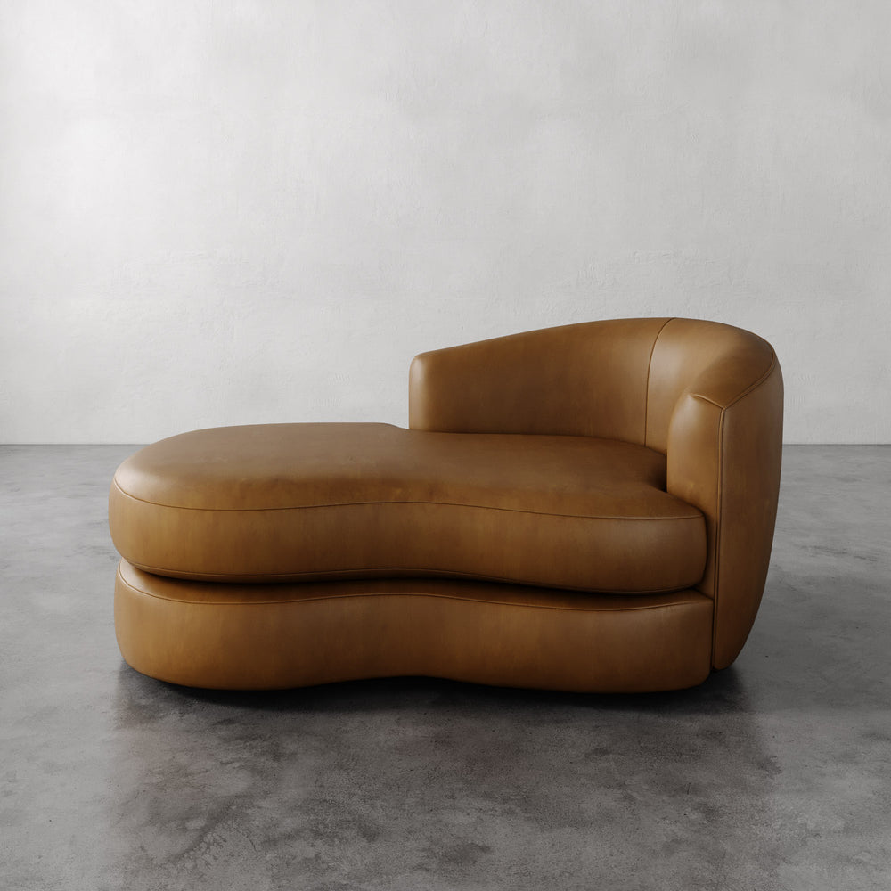 Lemieux et Cie Rulmann Leather Right Arm Chaise in warm tobacco, sculptural low-slung chaise with curved organic form, on polished concrete floor.