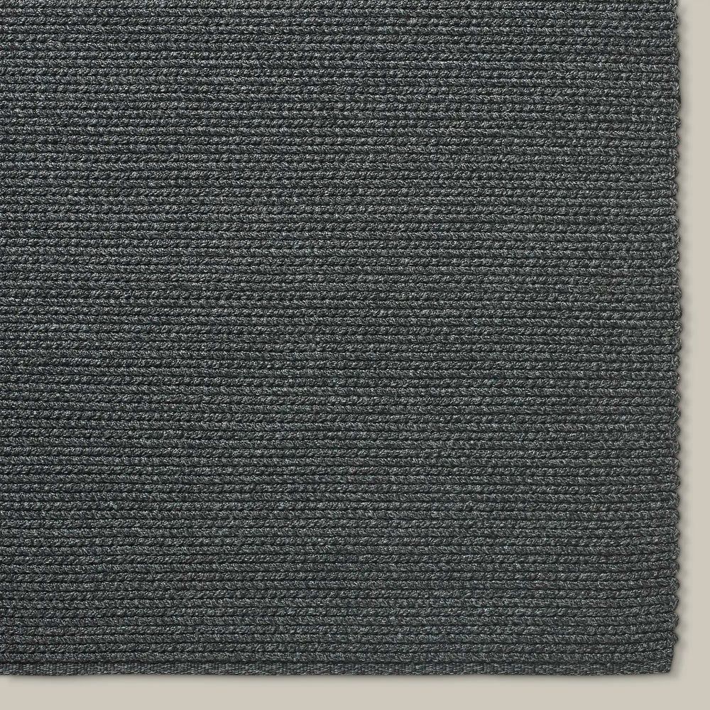 Lemieux et Cie Tricot Handwoven Outdoor Rug in charcoal, close-up detail of horizontal ribbed weave texture on neutral backdrop.