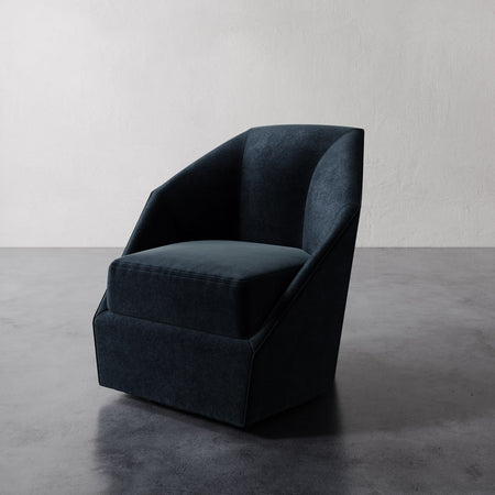 Lemieux et Cie Bijou Swivel Chair in dark teal, sculptural barrel-back swivel chair with curved silhouette on gray concrete floor.