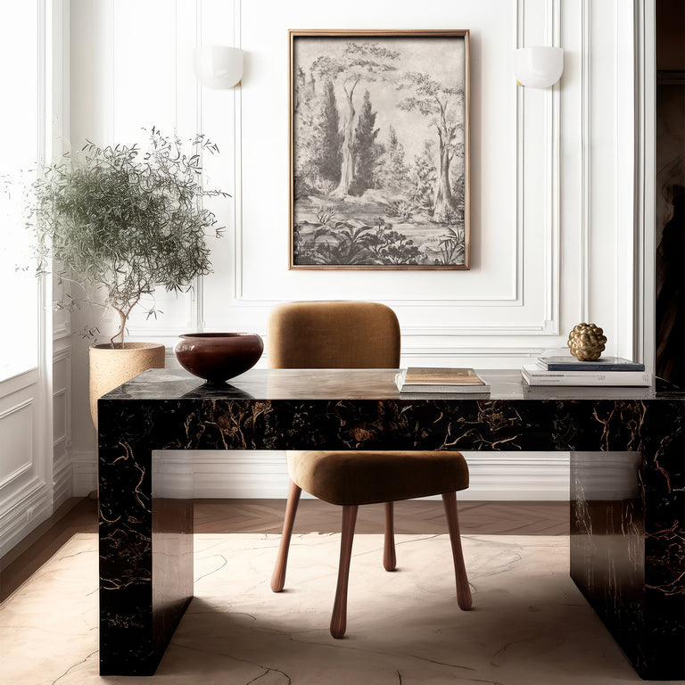 Lemieux et Cie Bois de Boulogne print in grisaille tones, framed panoramic art above a dark marble desk with tan upholstered stool in white-paneled room.