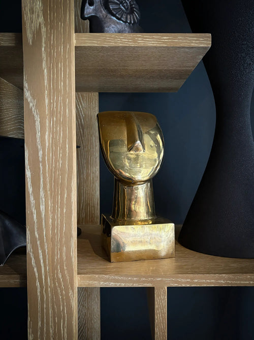Lemieux et Cie Vintage Art Deco Abstract Brass Bust Sculpture, solid brass with warm patina, displayed on open shelving in a room with dark blue walls.