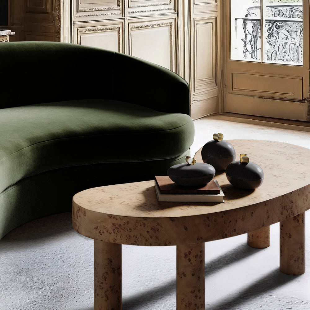 Lemieux et Cie Caillou Lidded Pots in black marble, organic rounded forms with brass knobs, styled on coffee table beside green sofa in Parisian sitting room.