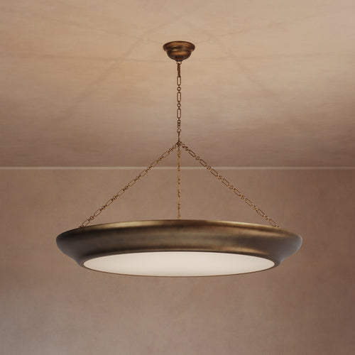 Lemieux et Cie Lenoir Chandelier in matte iron, sculptural bowl-form pendant suspended by chain, hung against neutral plaster ceiling and walls in warm light.