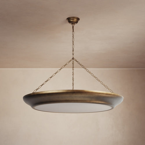 Lemieux et Cie Lenoir Chandelier, sculptural iron bowl form in matte finish suspended by handmade chain, hung in a neutral plaster-walled room.