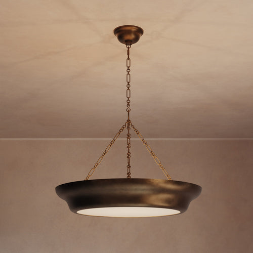 Lemieux et Cie Lenoir Chandelier, sculptural iron bowl-form pendant in dark matte finish, suspended by chain in a room with warm plaster ceiling and walls.