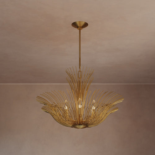 Lemieux et Cie Dorelle Chandelier, radiating spoke-form fixture in warm golden finish, suspended in a room with blush plaster walls and ceiling.