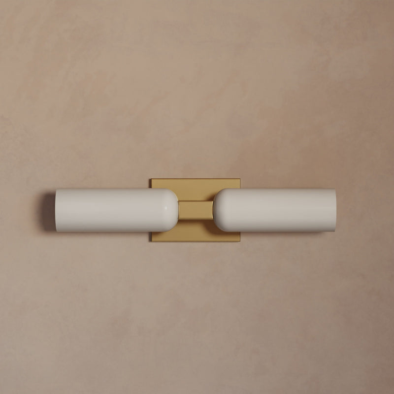 Lemieux et Cie Maroux Double Sconce with opal glass cylinders and burnished brass rectangular mount, wall sconce shown against blush plaster wall.