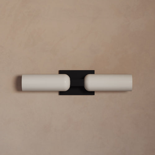 Lemieux et Cie Maroux Double Sconce with dual opal glass cylinders and dark mount, wall-mounted sconce on warm plaster wall.