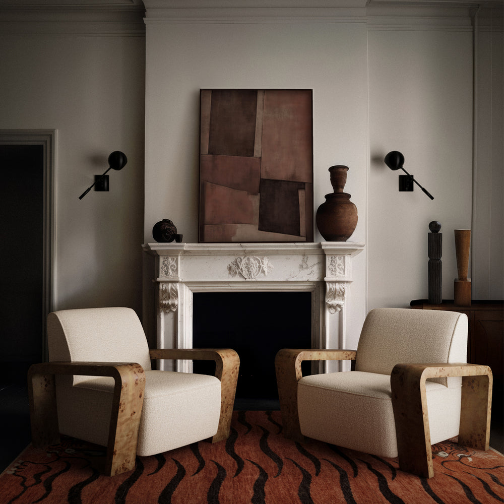 Lemieux et Cie Dumas Lounge Chair in cream performance bouclé with oak burl arms, styled flanking a carved marble mantle in a neutral-walled sitting room.