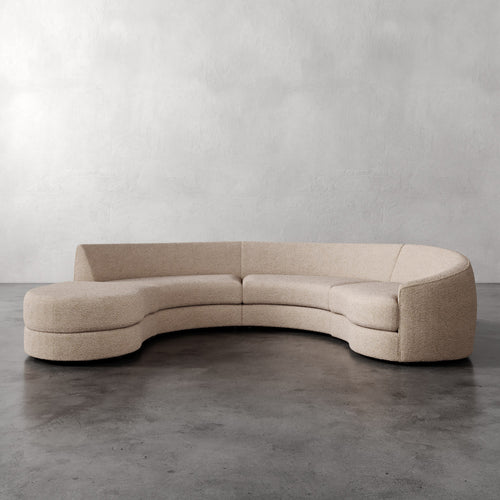 Lemieux Et Cie Rulmann 3-Piece Right Sectional  Beige curved sofa on a gray floor with a plain gray wall background