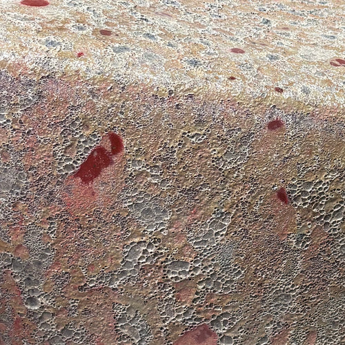 Close up of the glaze texture of the Ember Ash ceramic stool and end table with reactive glaze. Handmade for indoor and outdoor use. 