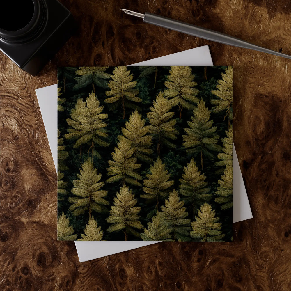 Lemieux et Cie Forest Evergreen greeting card swatch, botanical fern motif on dark ground, shown on figured wood desk with white paper and pen.