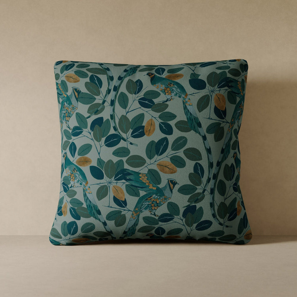 Lemieux et Cie Modern Peacock Velvet Pillow in teal and gold botanical motif, performance velvet pillow shown against warm neutral wall.