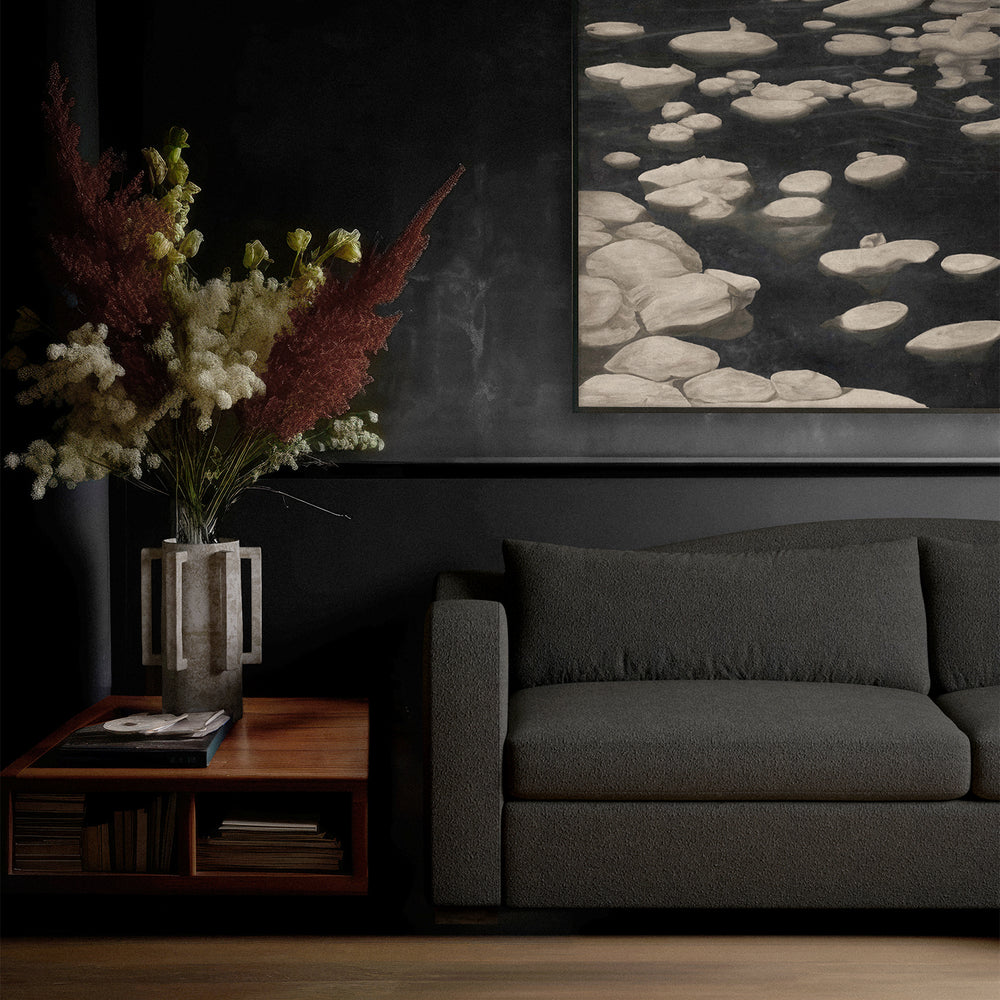 Lemieux et Cie Elodie Sofa in charcoal bouclé, deep-seated sofa with sculptural arms, styled in dark-walled sitting room with wood floors and artwork.