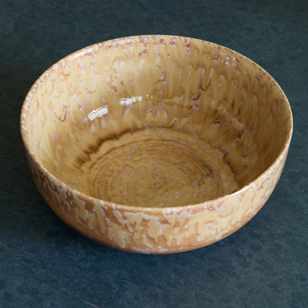 Lemieux et Cie Hanami Stoneware Serving Bowl in sand with reactive glaze, shallow rounded form with organic tonal variations, shown on dark stone surface.