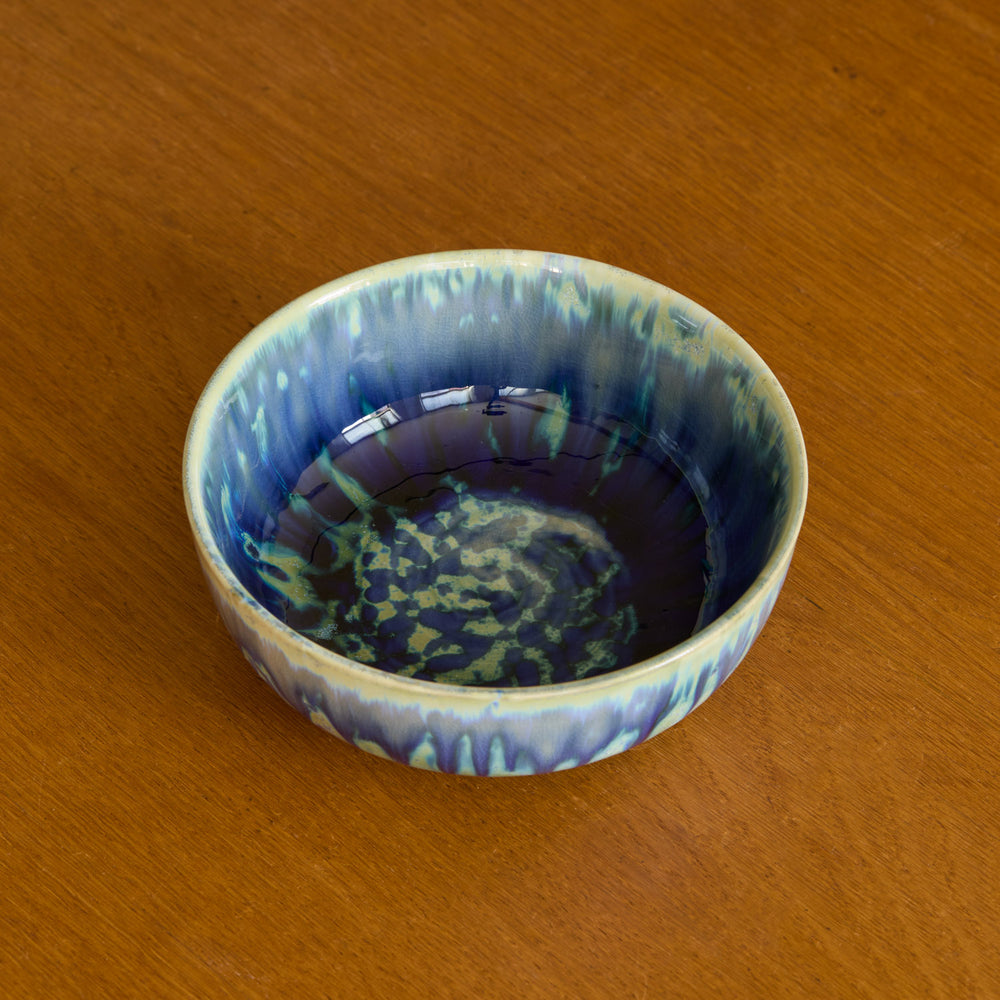 Lemieux et Cie Hanami Stoneware Bowl in indigo with reactive glaze, showing tonal shifts and crazing, resting on warm wood surface.