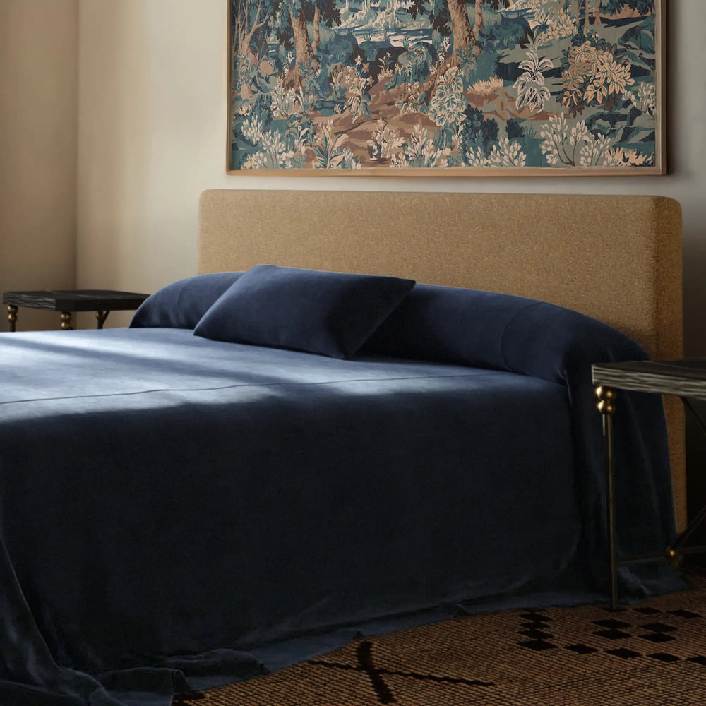 Lemieux et Cie Heavy Linen Lumbar Pillow Cover in Indigo, dark navy lumbar pillow on upholstered bed with brass nightstands and framed tapestry art.