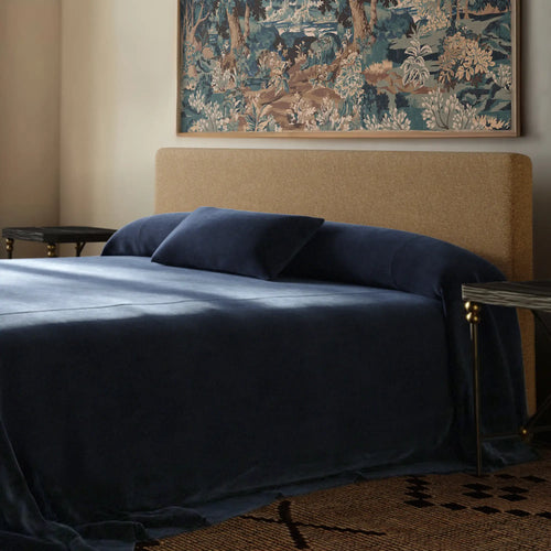 Lemieux et Cie Heavy Linen Lumbar Pillow Cover in Indigo, dark navy lumbar pillow on upholstered bed with brass nightstands and framed tapestry art.