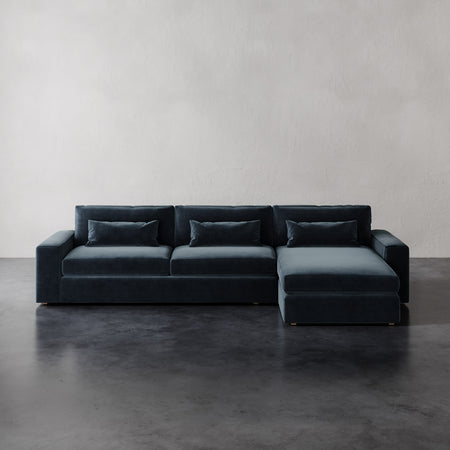 Lemieux et Cie Lacroix Right Chaise Sectional in charcoal velvet, low-profile modular sofa with bolster pillows, shown on dark concrete floor.