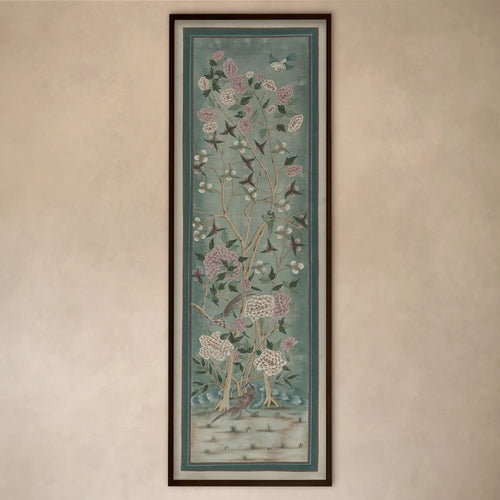 Lemieux et Cie Jardin de Jaipur art panel, vertical framed print depicting flowering branches and birds in soft blue-green tones, hung on warm neutral wall.