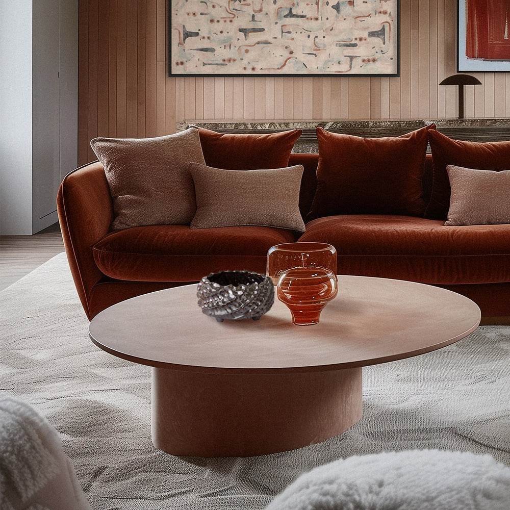 Lemieux et Cie handmade pinched clay bowl in charcoal, ceramic vessel styled on oval coffee table in sitting room with wood-paneled walls.