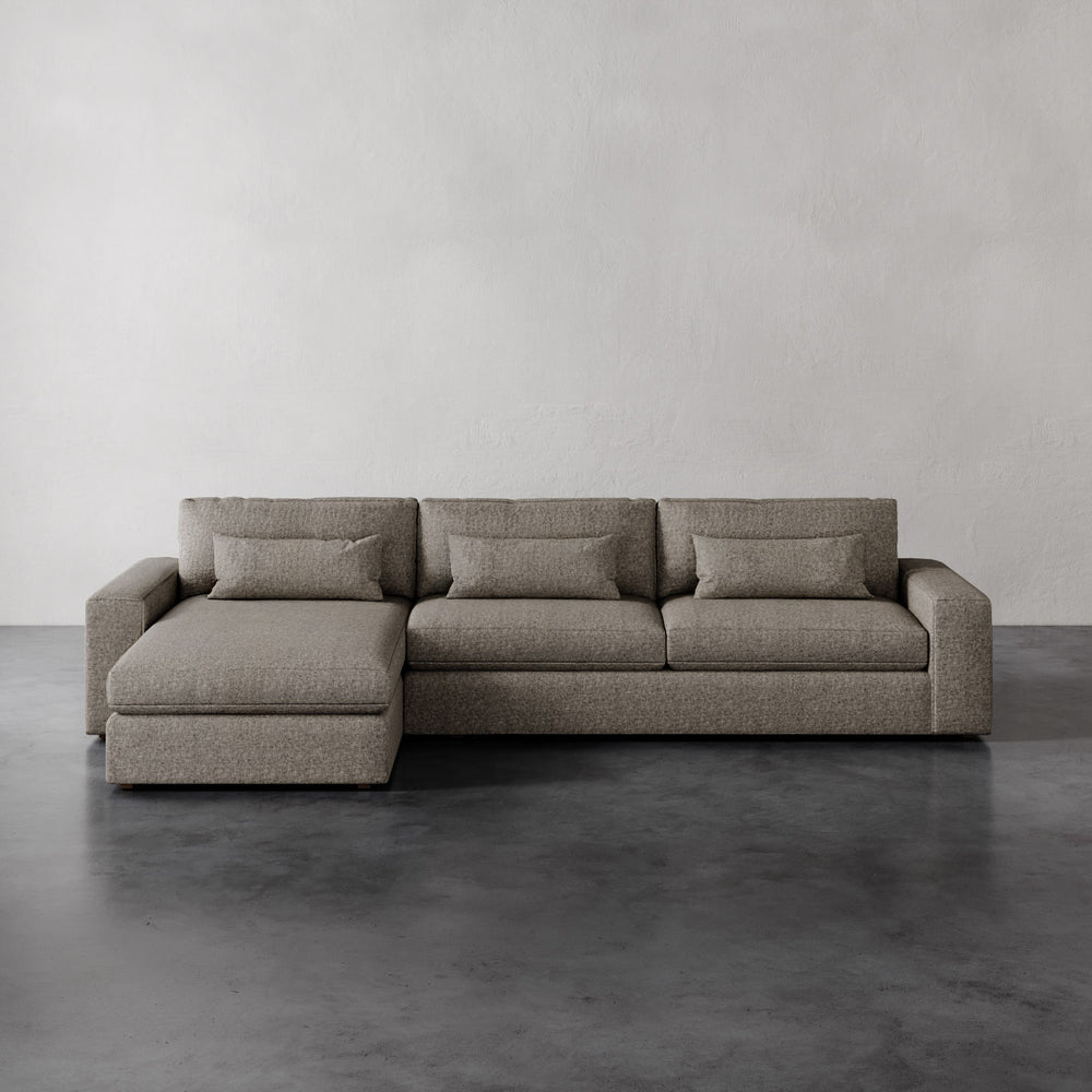 Lemieux et Cie Lacroix Left Chaise Sectional in warm taupe upholstery, low-profile modular sofa on dark concrete floor against neutral walls.