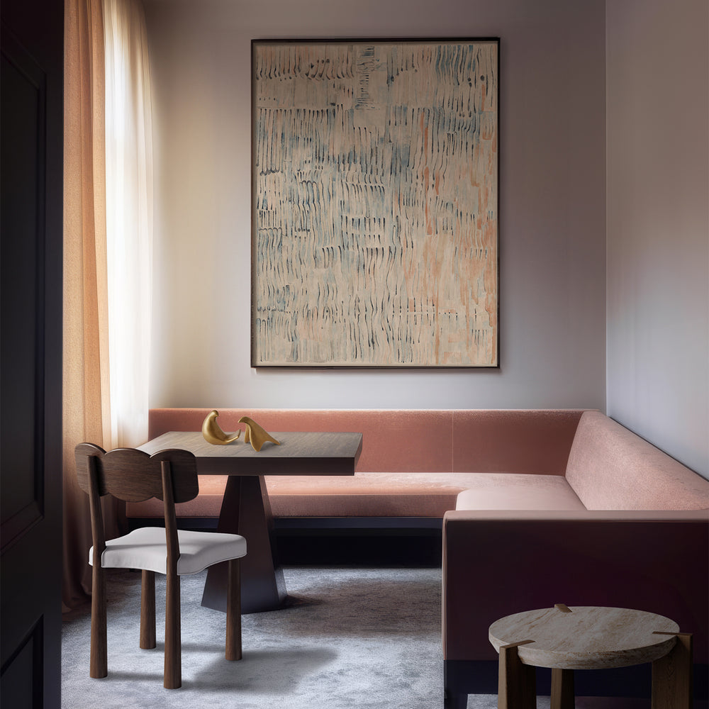 Lemieux et Cie Étretat Limited Edition Art Print, abstract coastal artwork in neutral tones with blue accents, hung above blush pink banquette seating in dining nook with soft natural light.