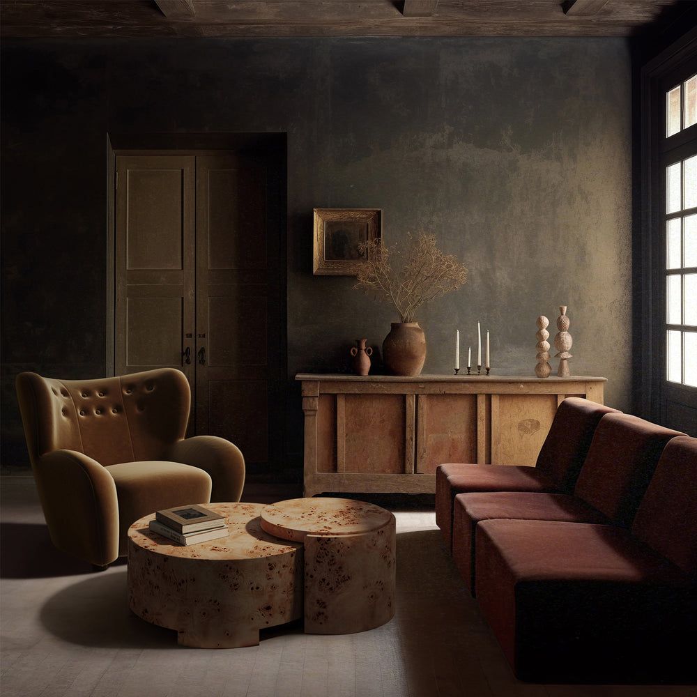 Lemieux et Cie Mondaine Lounge Chair in warm tan upholstery with button-tufted back, shown in a sitting room with textured plaster walls and stone flooring.