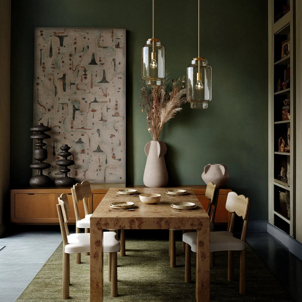 Lemieux et Cie Nodier Pendant, cylindrical clear glass pendants suspended above a dining table in a room with deep green walls and wood sideboard.