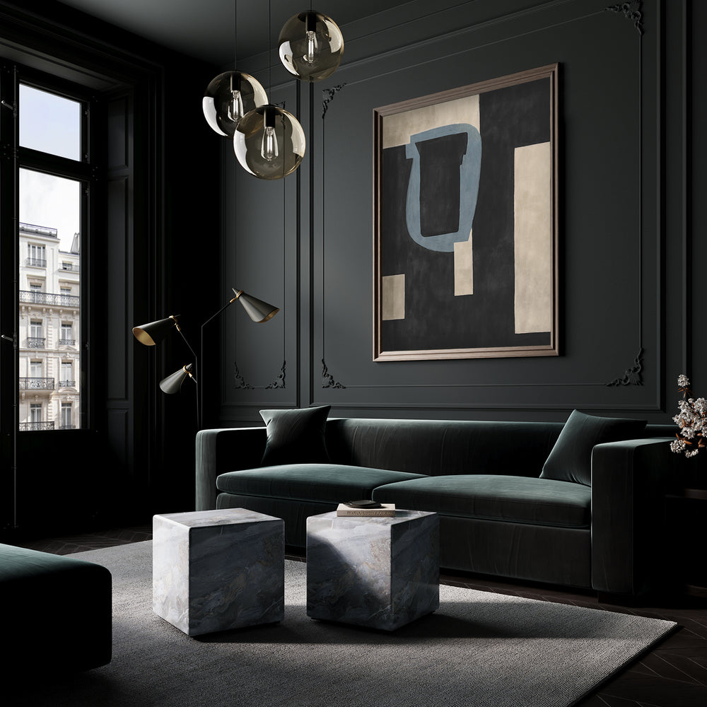 Lemieux et Cie L'Étang fine art print in black and blue geometric forms, framed artwork above a deep green sofa in a dark-paneled sitting room with marble cube tables.