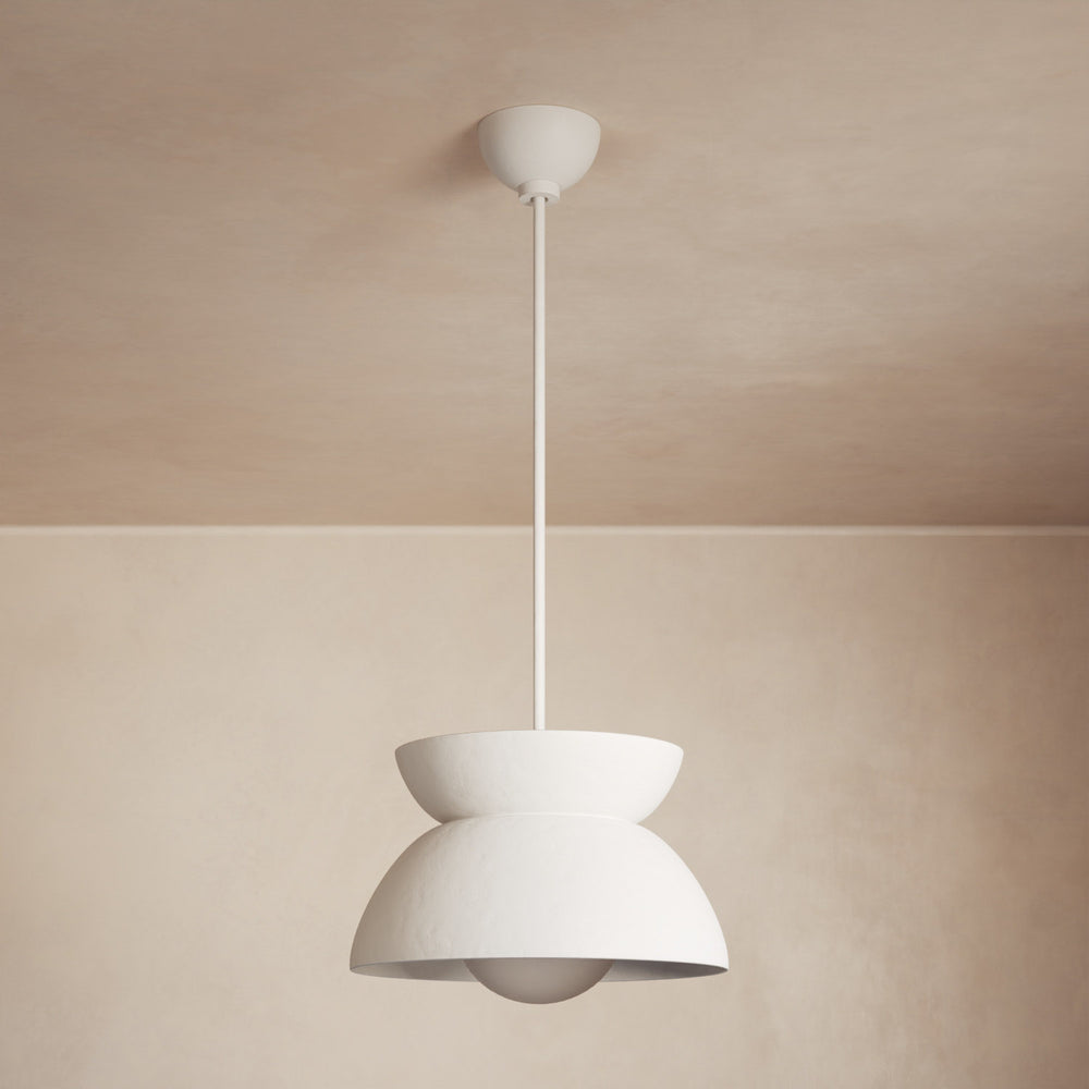 Lemieux et Cie pendant light with sculptural stacked bowl form in warm white, hanging against neutral plaster walls and ceiling in soft light.