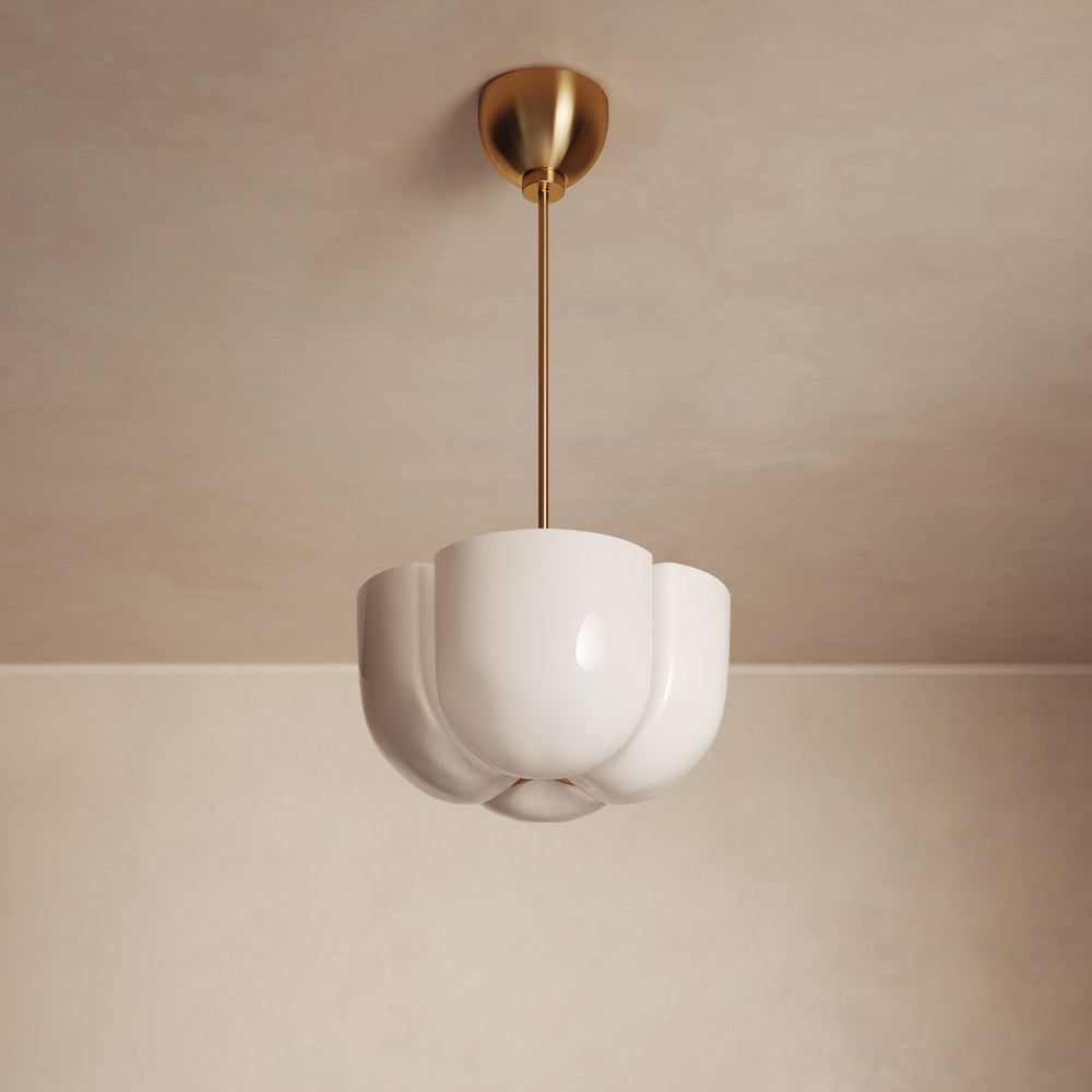 Lemieux et Cie Cheverny Pendant with sculptural white scalloped shade on slim brass rod, ceiling-mounted in soft neutral plaster room.