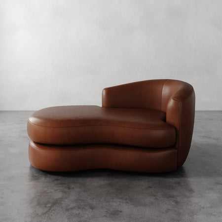 Lemieux et Cie Rulmann Leather Right Arm Chaise in warm brown leather, sculptural curved chaise shown on polished concrete floor against white walls.