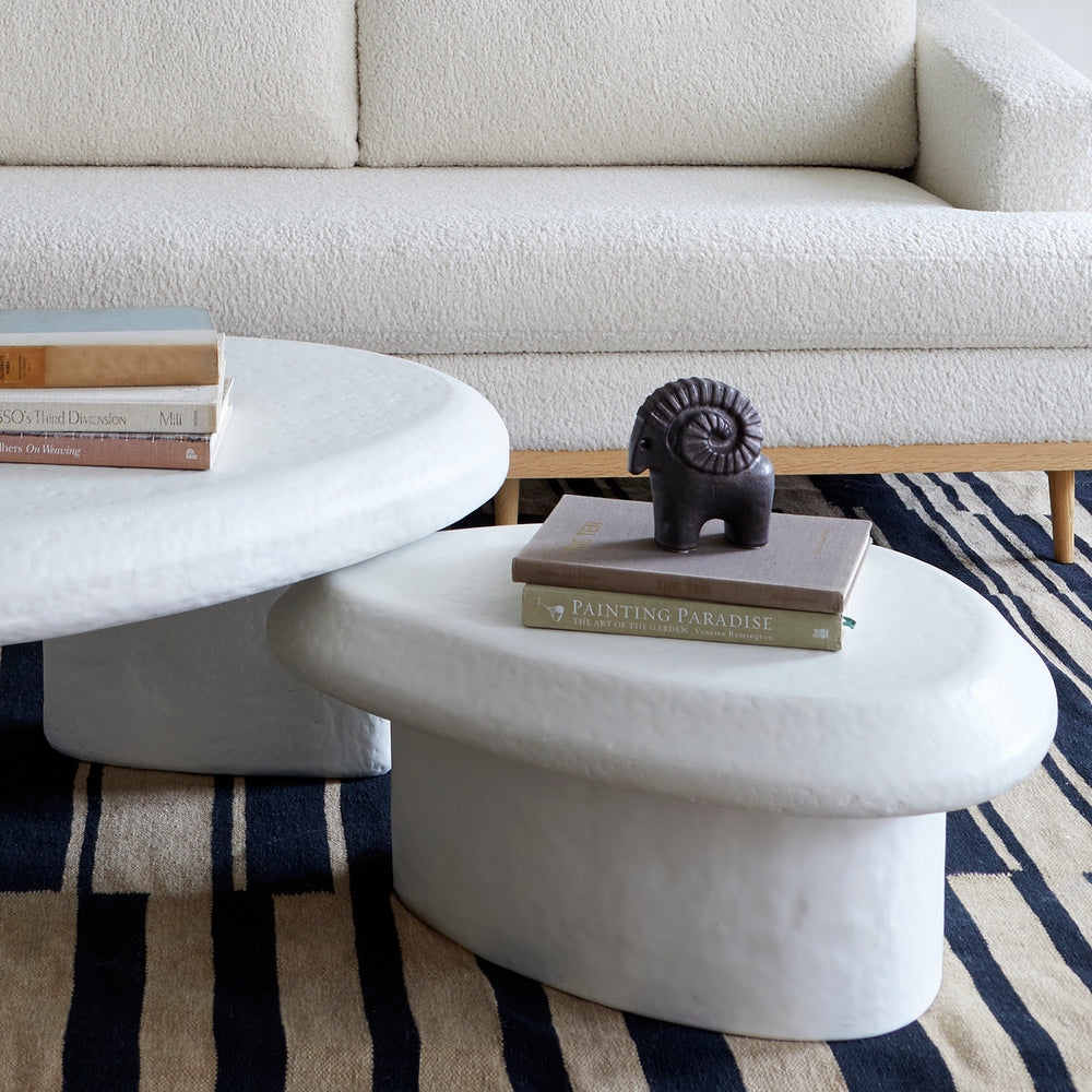 Lemieux et Cie Ram in textured black glaze, hand-modeled ceramic sculpture, styled on white marble coffee table beside ivory bouclé sofa in living room.