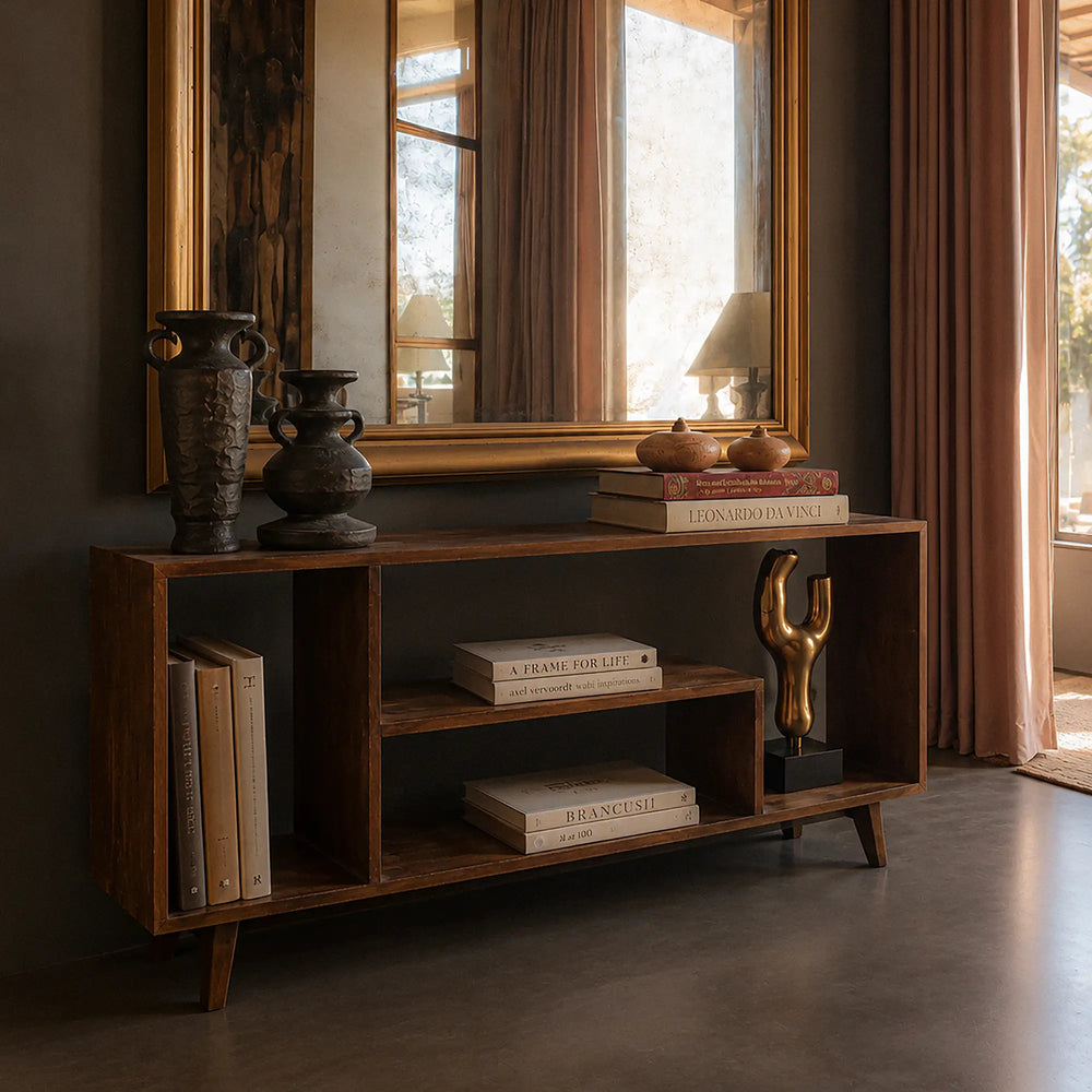 Lemieux et Cie Pierre Jeanneret bookcase in solid teak - styled room scene with a large gold framed mirror above, the bookcase styled with books, vases and decor