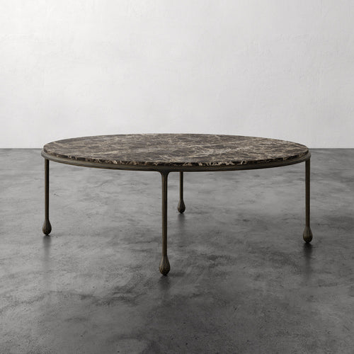 Lemieux et Cie Ravelle Oval Coffee Table in Emperador marble with aged bronze iron frame, low-profile table on polished concrete floor.