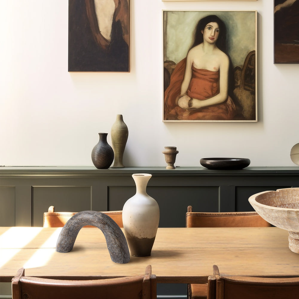 Lemieux et Cie Salette Arch sculptural form in textured charcoal, decorative object shown on light wood dining table with vintage portraiture and green paneled sideboard.